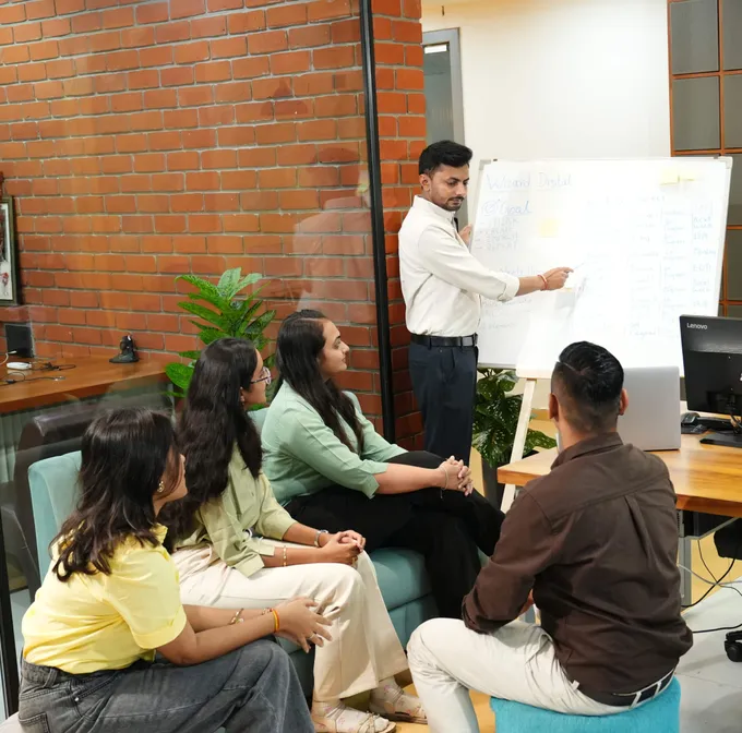 Wizard Infosys team collaborating around a laptop