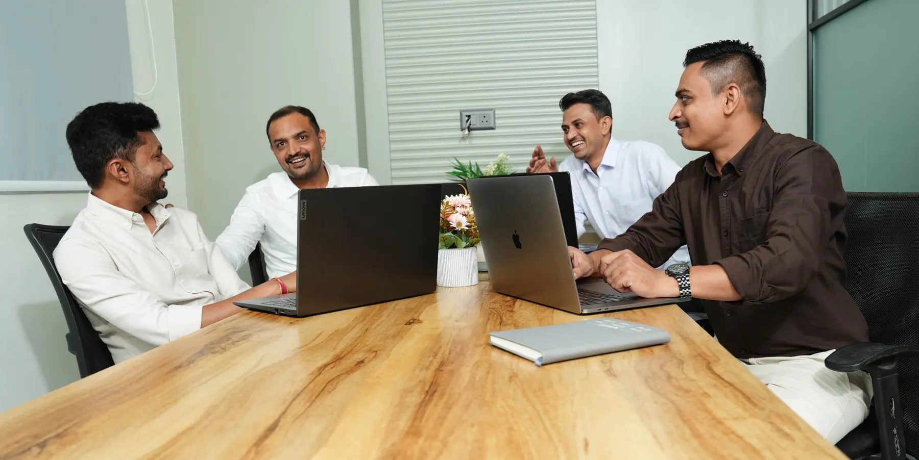 Team members working together on laptops around the table