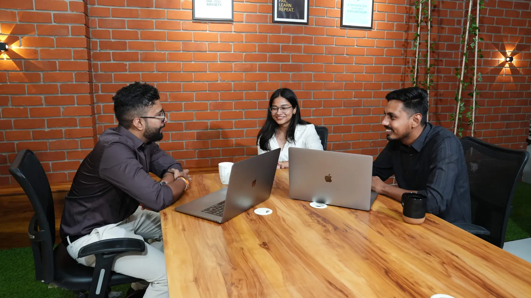 The team discussing a project around a laptop